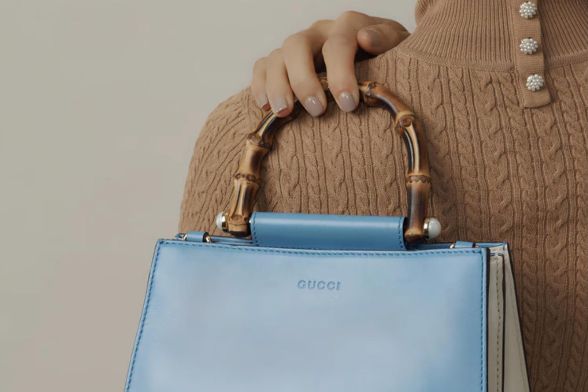 Woman holding lbue gucci handbag