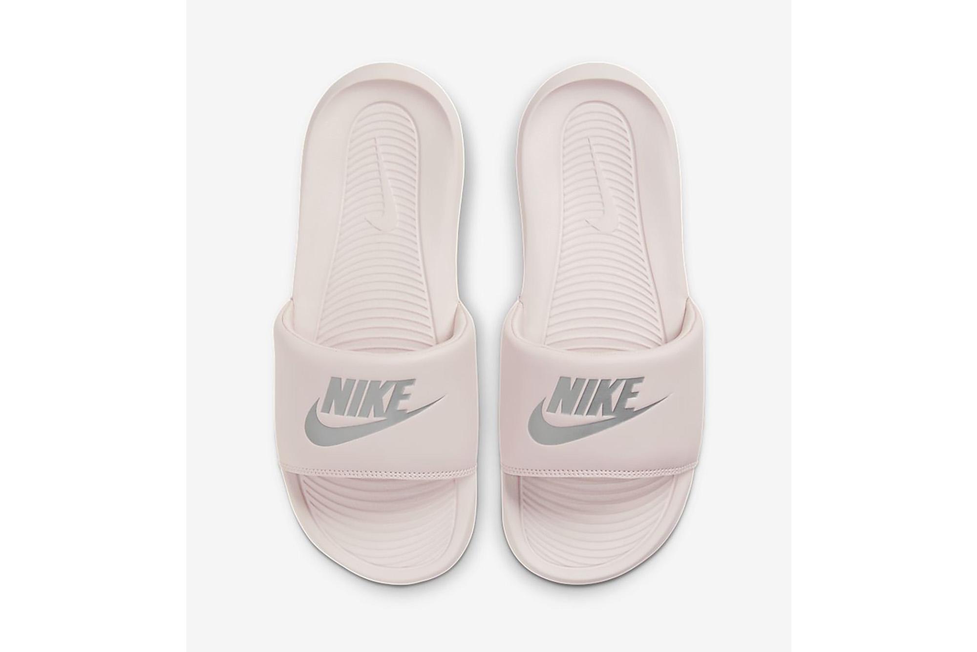 A pair of light pink Nike slides