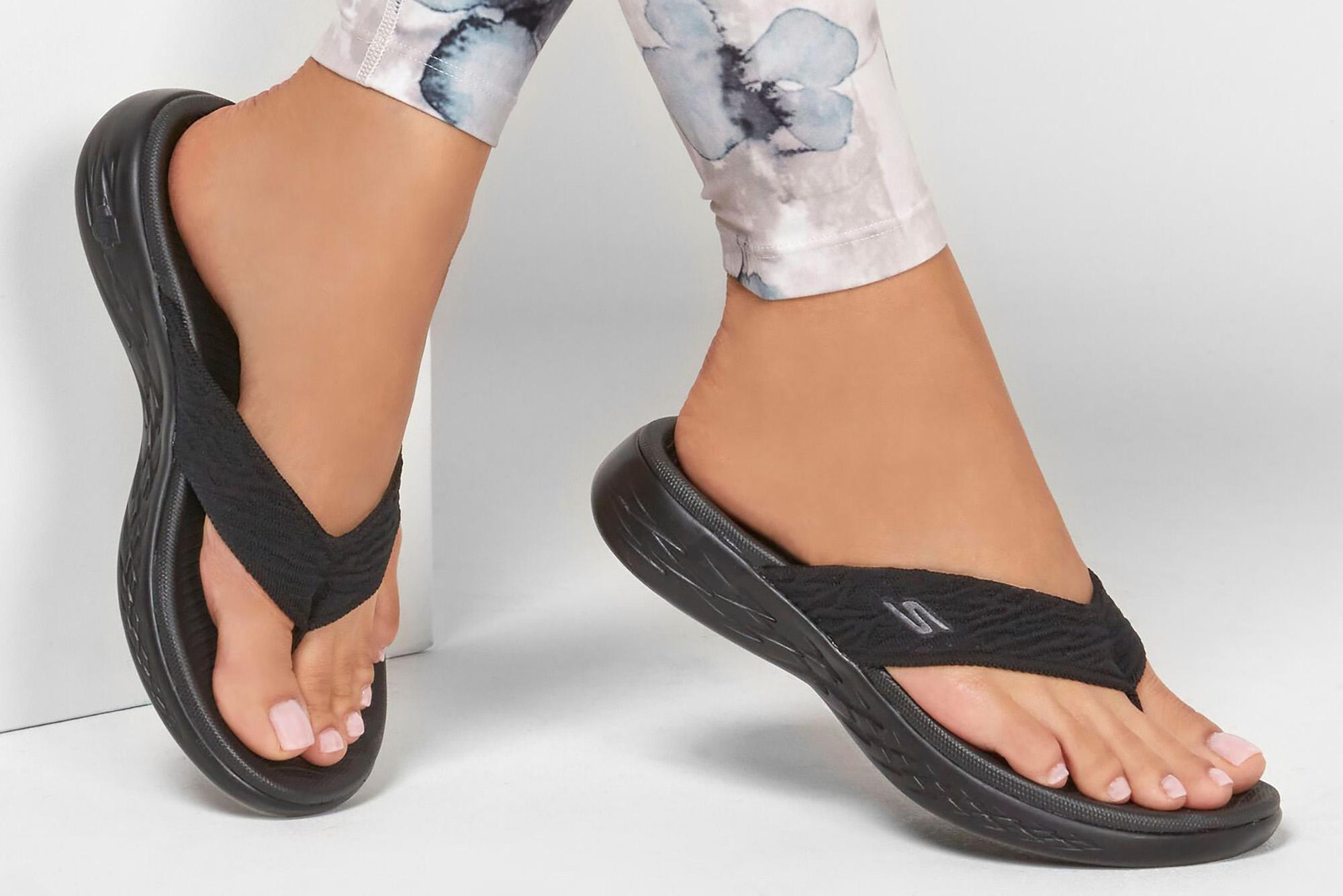 A pair of black flips flops on a woman