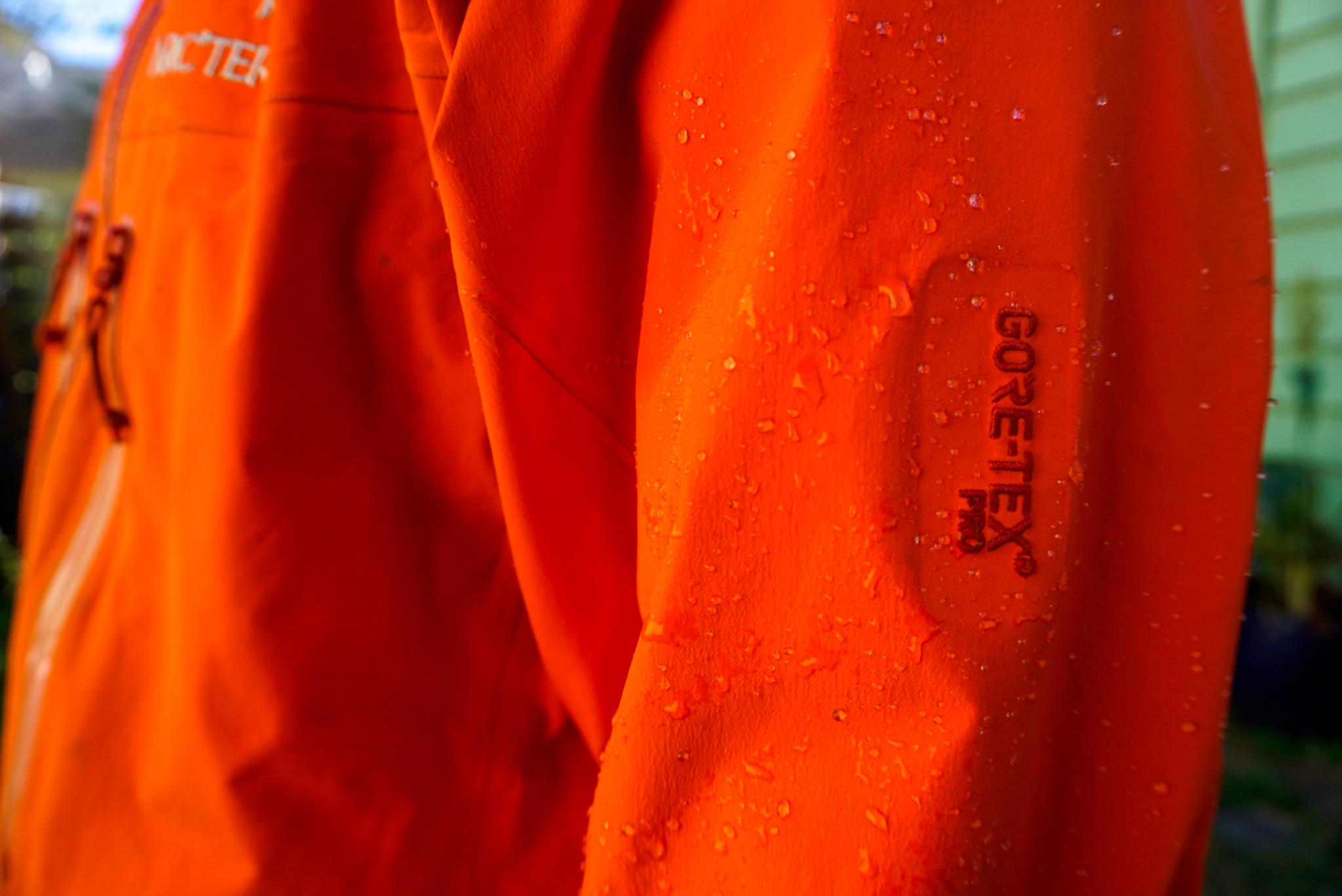 The Outdoor Research Helium Rain Jacket Stuffed Into Pocket and Hanging From Climbing Harness