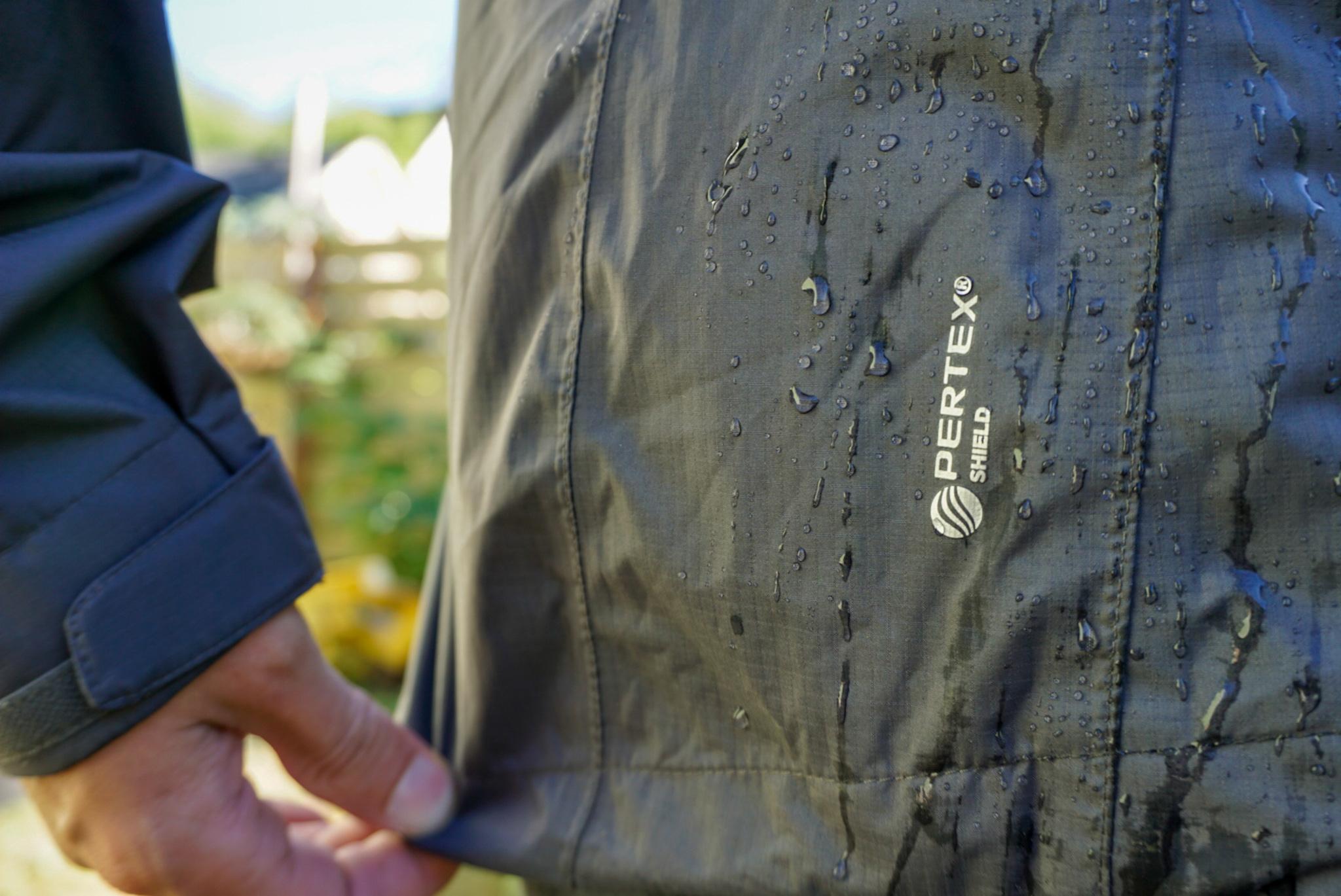 A Climber Descends Into a Hole in the Rock Wearing the Outdoor Research Helium Rain Jacket