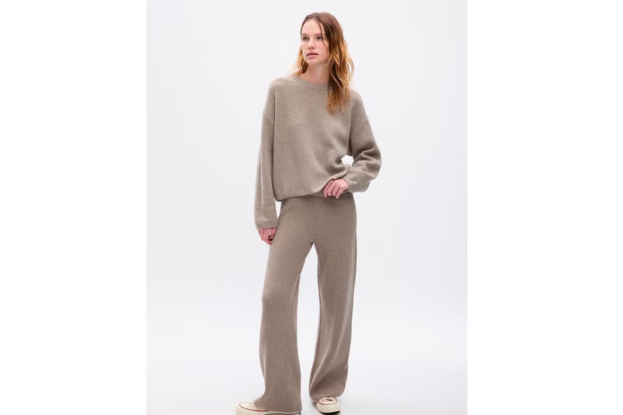 Woman in ribbed sweater and slouchy pants.