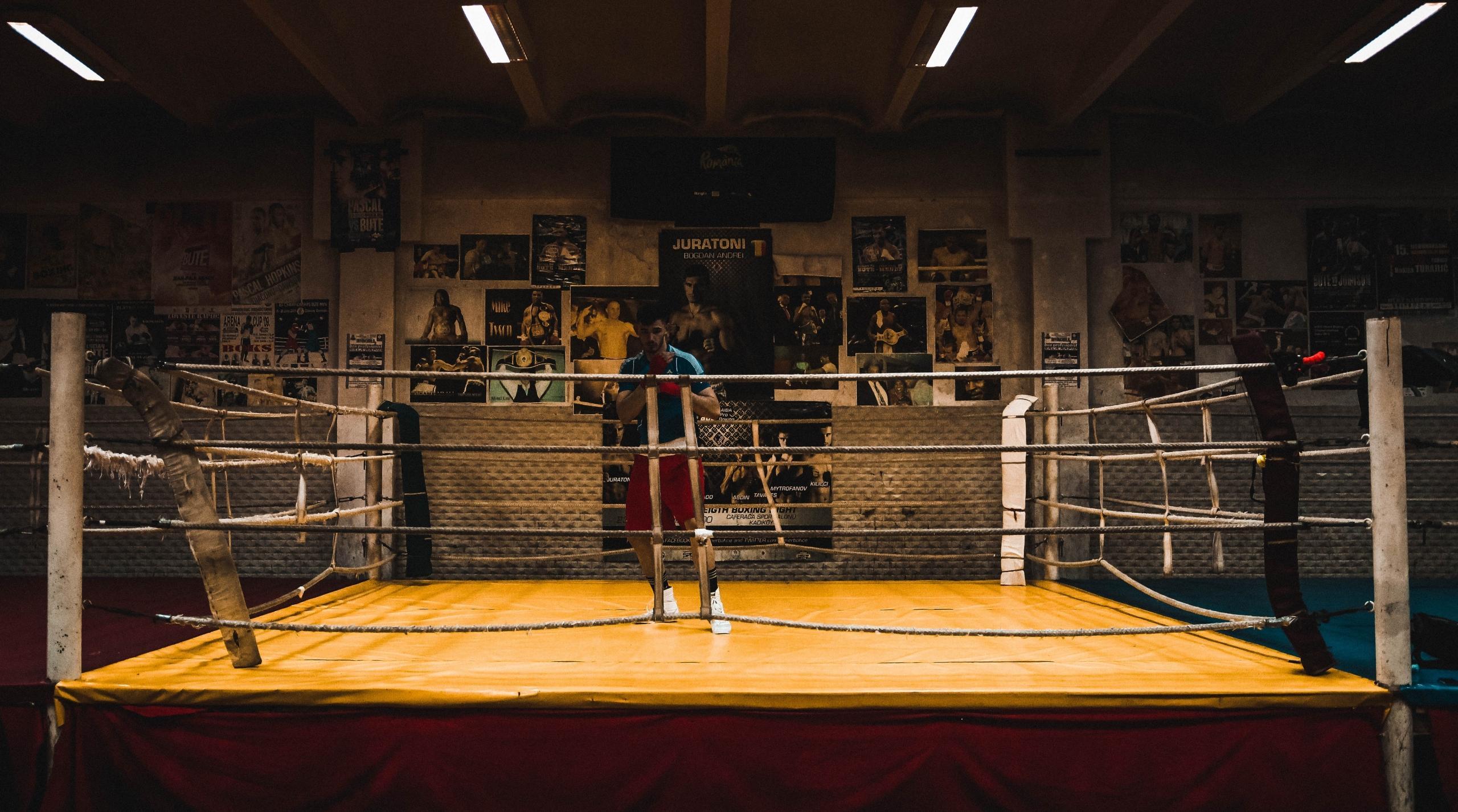 A boxing trainee stands in the middle of the ring