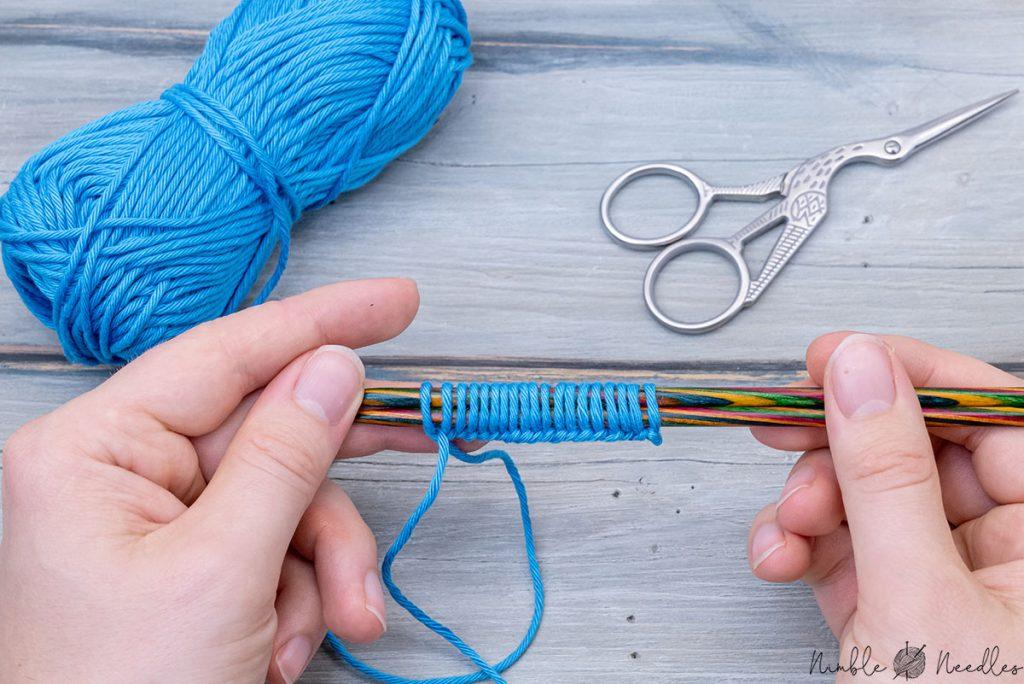 casting on stitches with two needles - someone holding it up with their fingers