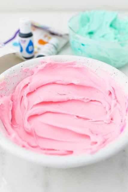 A unicorn cupcake decorated with piped colored frosting swirls and sprinkles.