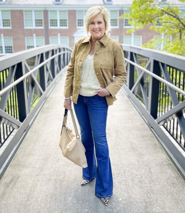 Over 40 Fashion Blogger, Tania Stephens, is carrying a neutral handbag with jeans and animal print heels