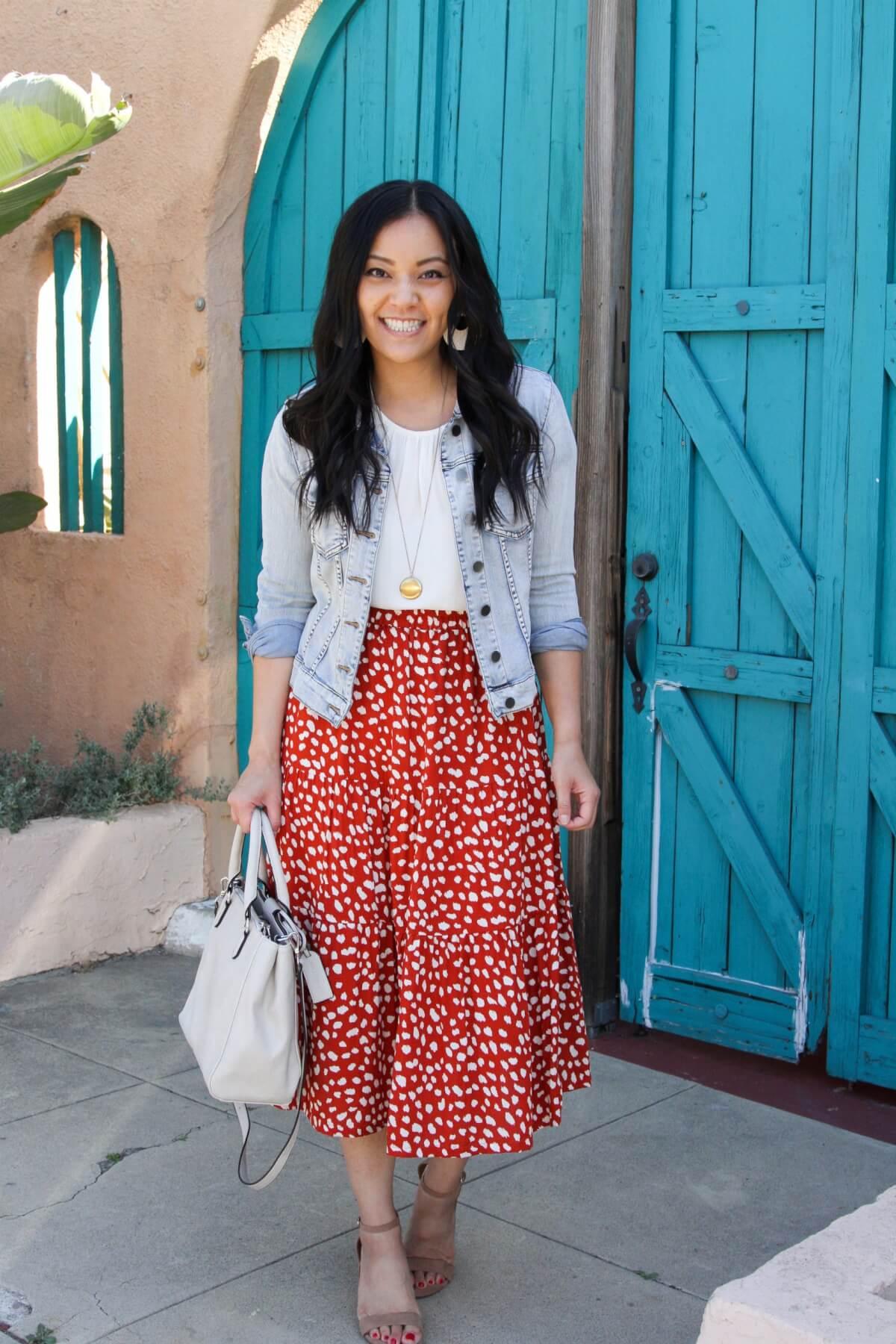 denim jacket outfit: denim jacket + cream top + red and white skirt + nude sandals + pendant necklace + white bag