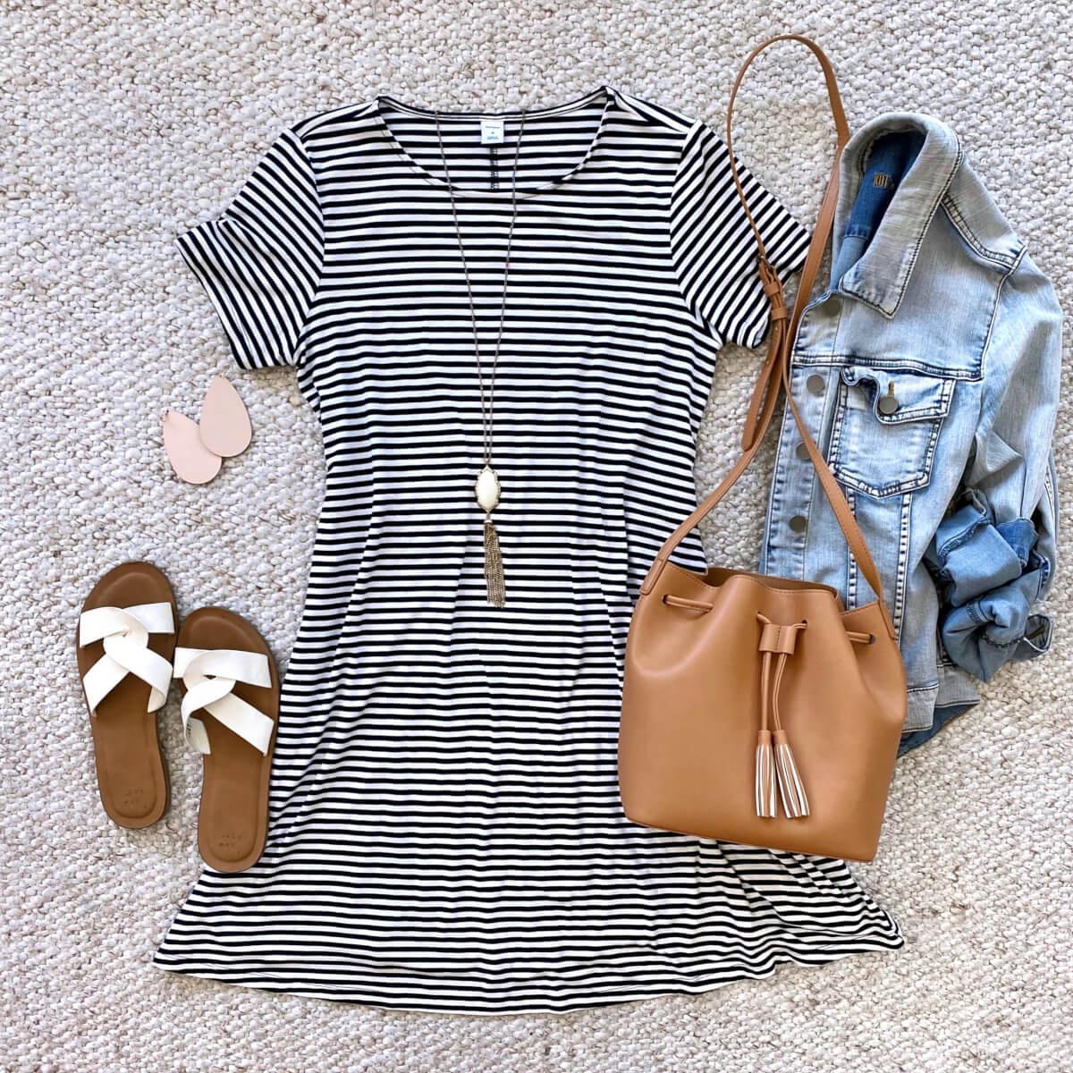 denim jacket outfit: denim jacket + striped dress + white sandals + blush earrings + pendant necklace + tan bag flat lay