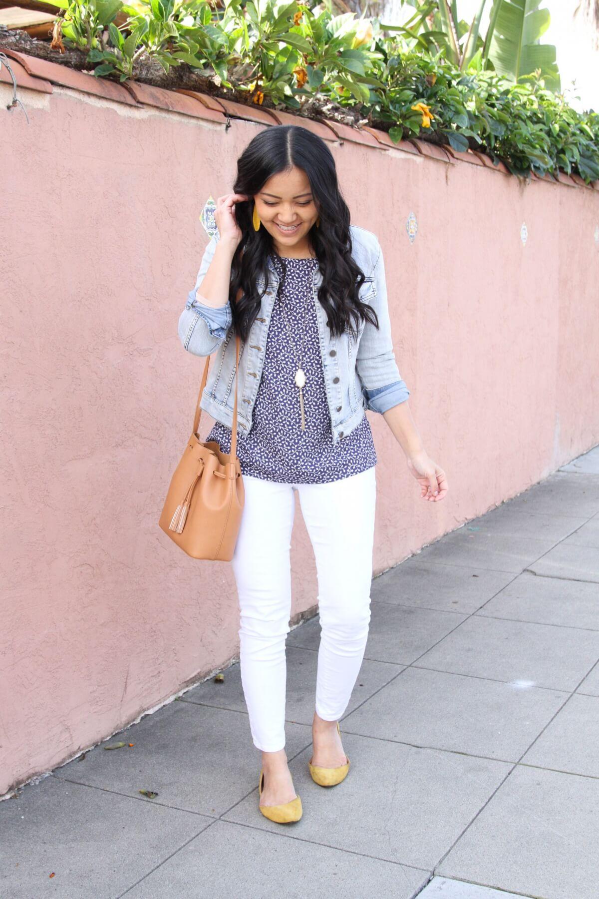 denim jacket outfit: denim jacket + blue and white top + white jeans + yellow flats + yellow earrings + pendant necklace + brown bag