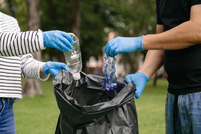 girls put plastic waste in a bag