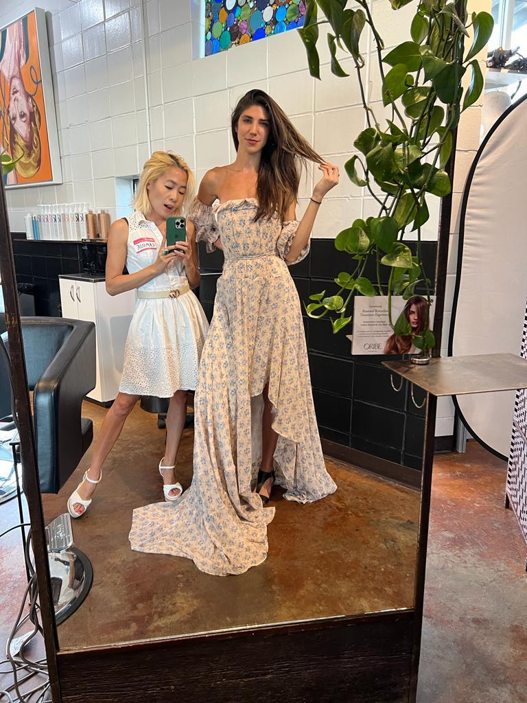 two ladies trying on the dresses from the clothing swap