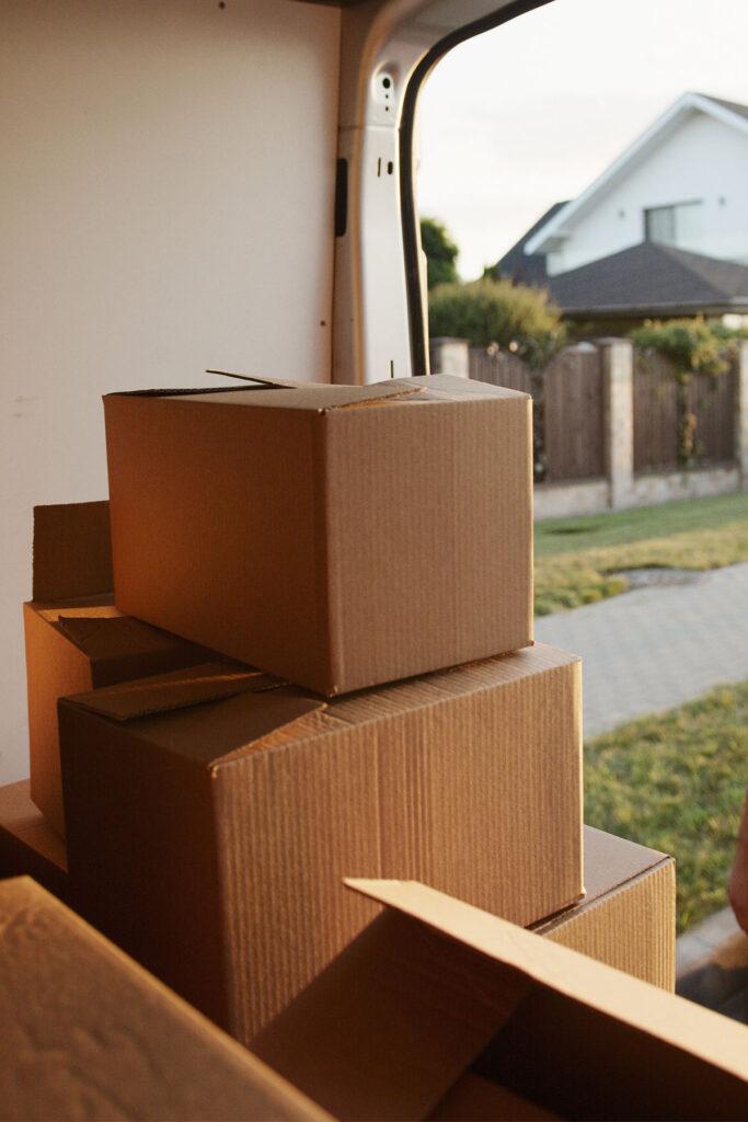 a pile of brown cardboard boxes in the back of a mail truck.