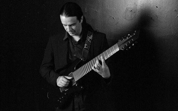 artist playing a 9 string guitar black and white photo