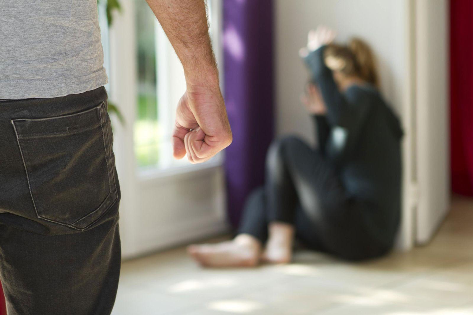 Man Holding Fist at Partner Cowering in Fear