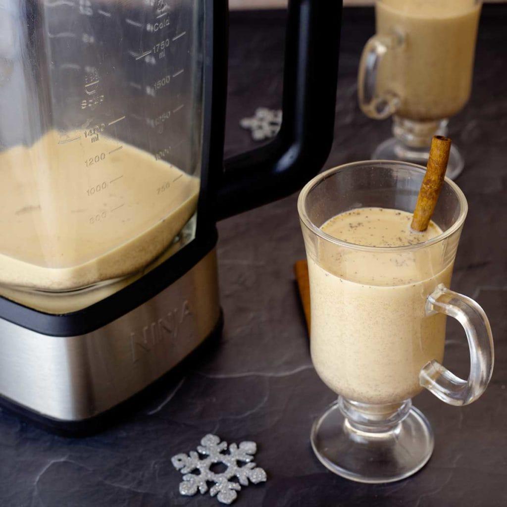 Pina Colada in a glass next to a pineapple and coconut