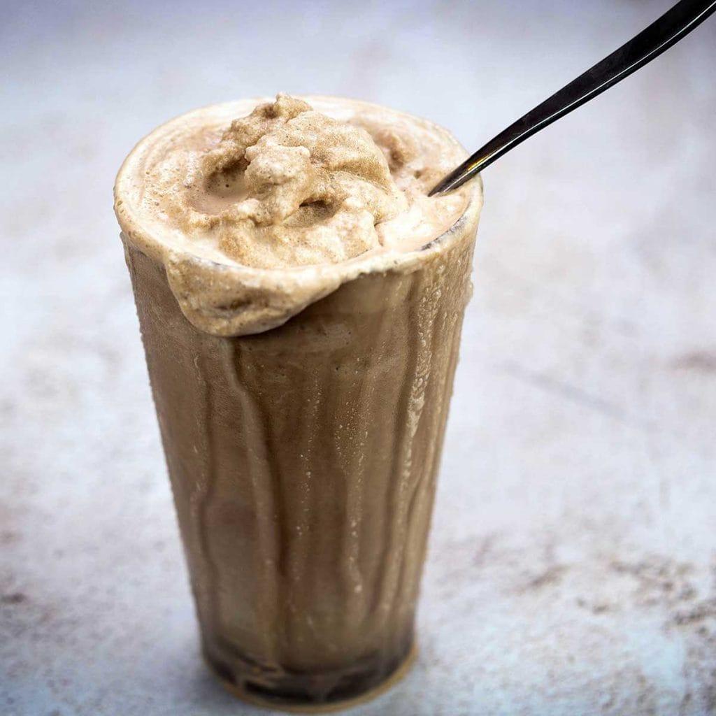 Orange Milkshakes with sliced oranges next to them and a full orange