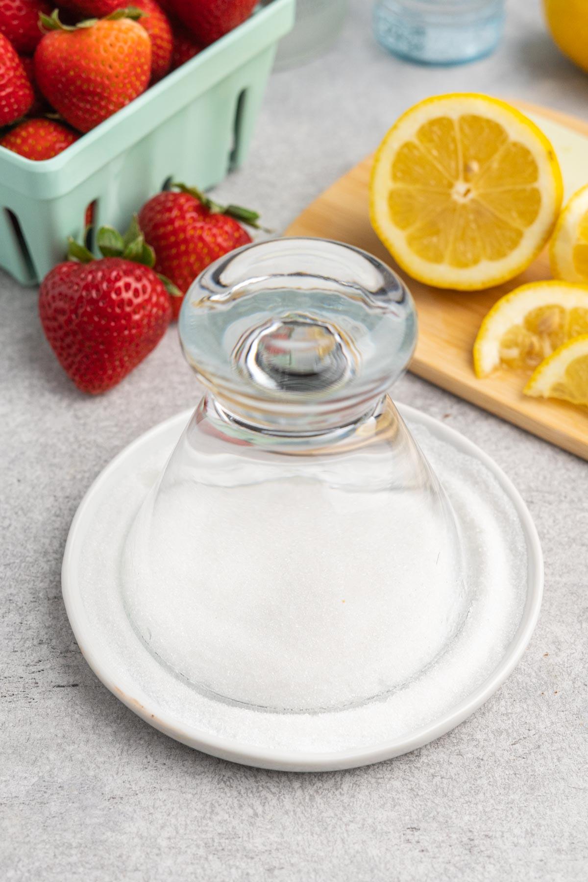 Martini glass upside down in a dish of sugar.