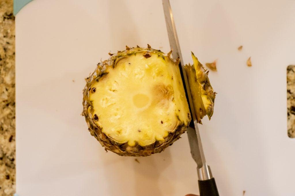 cutting pineapple rind off from top down