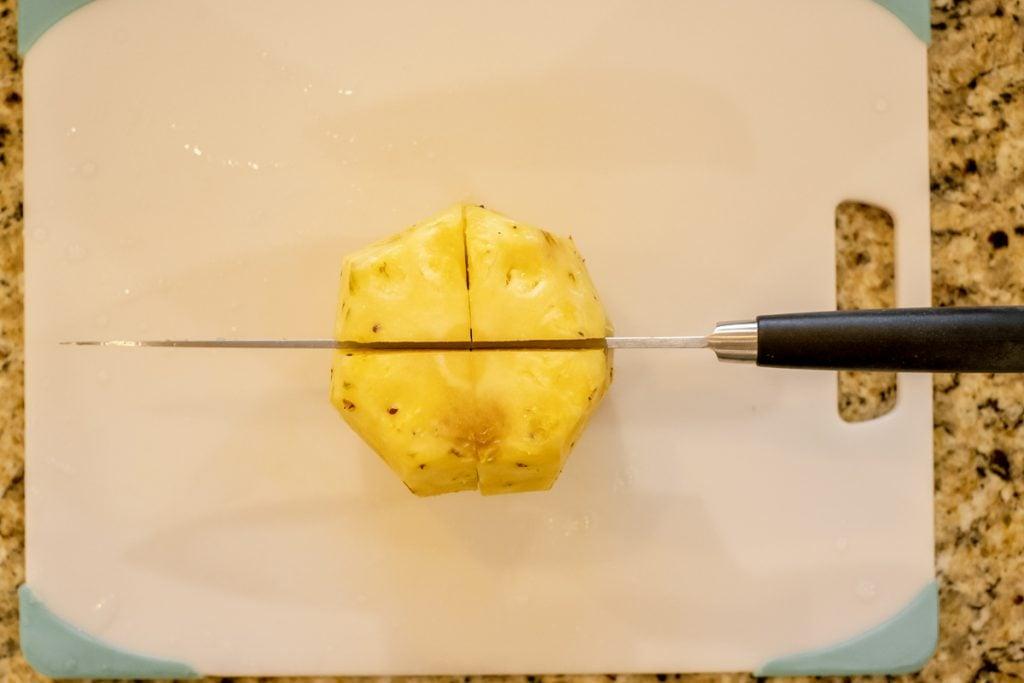 cutting pineapple into quarters