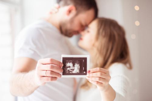 family holds baby picture to camera