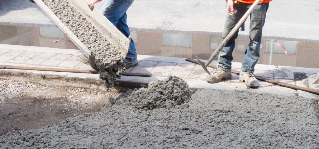 Workers pouring concrete on a construction site.