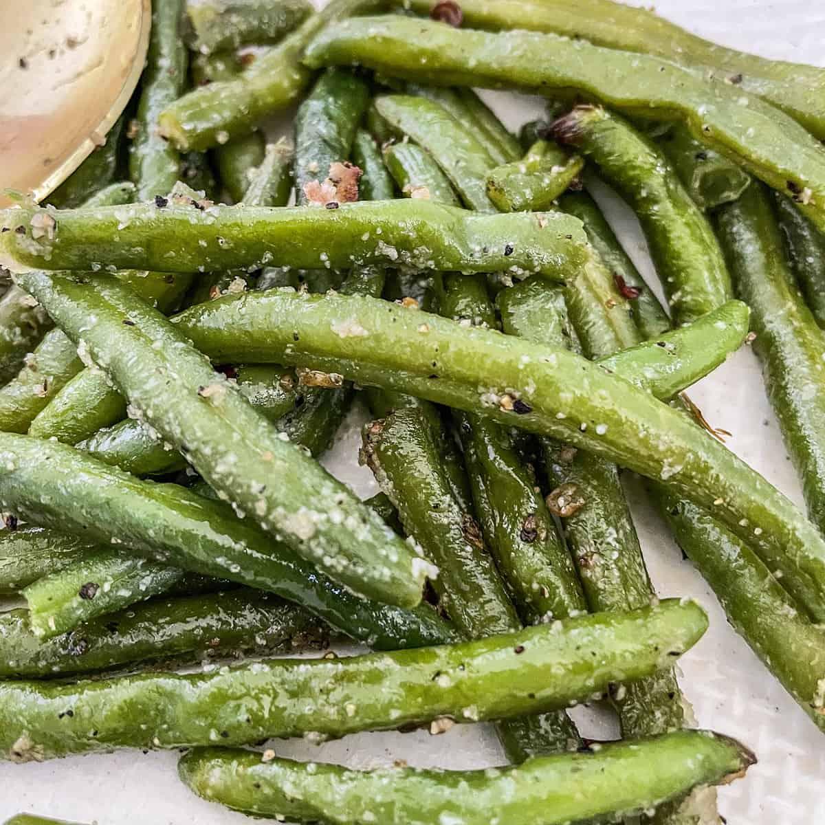 Frozen green beans on a baking tray lined with baking paper.