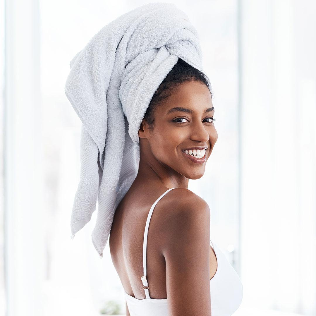 Beautiful young woman with a white towel on her head