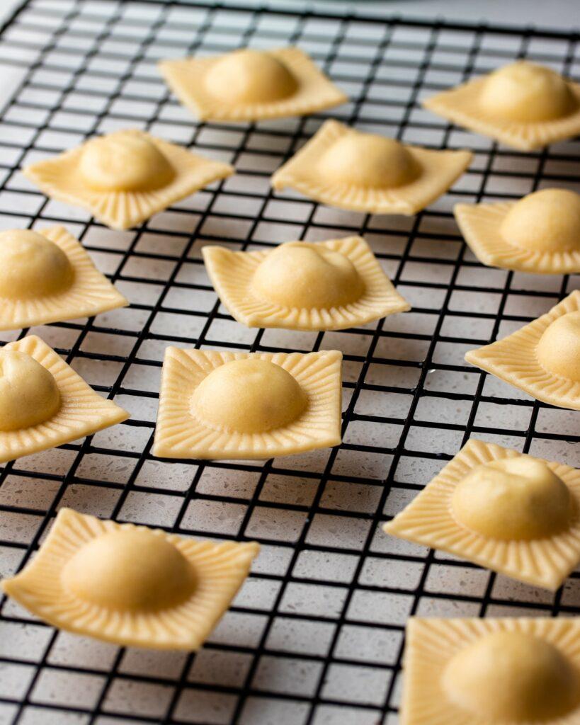 Blanched ravioli on a baking rack.