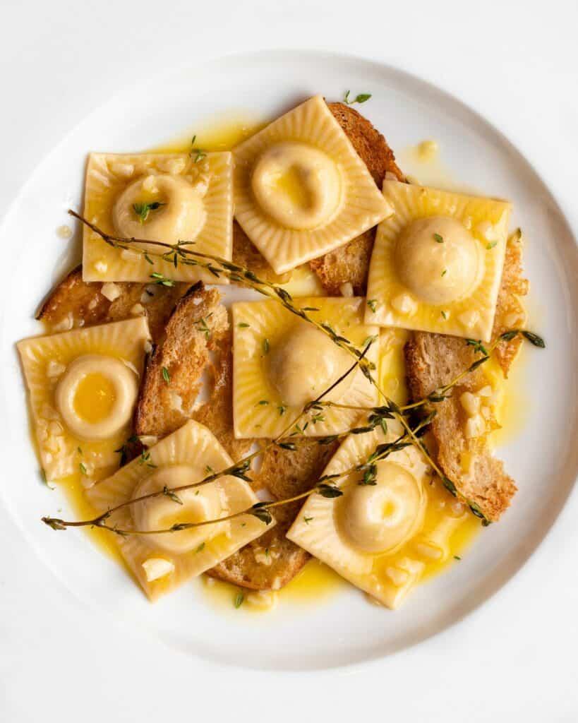 Ravioli in a butter sauce with sourdough croutons, thyme and garlic.